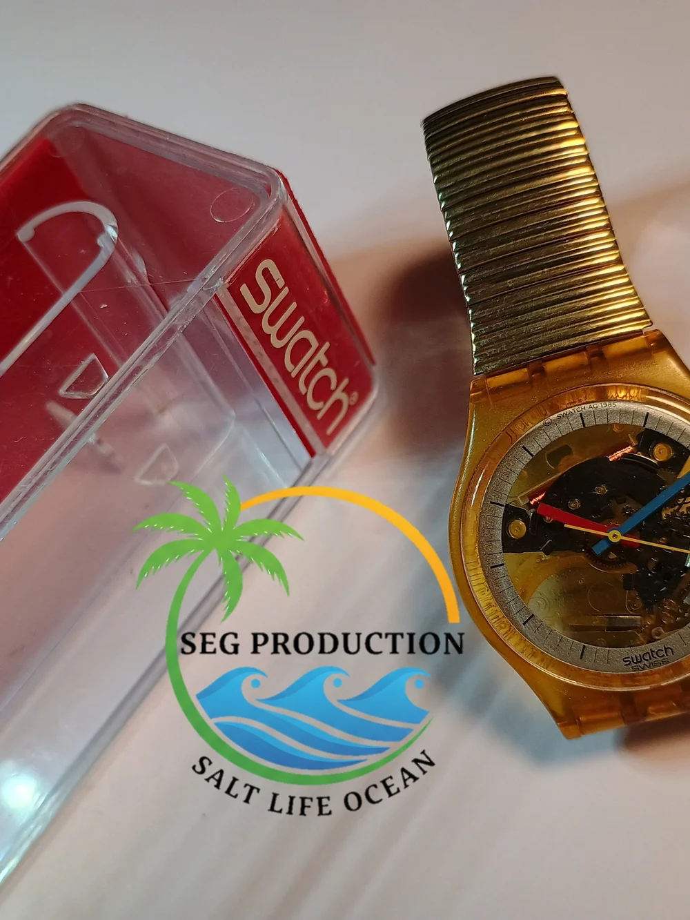 Swatch Gold Transparent Dial Watch with Blue and Red Hands